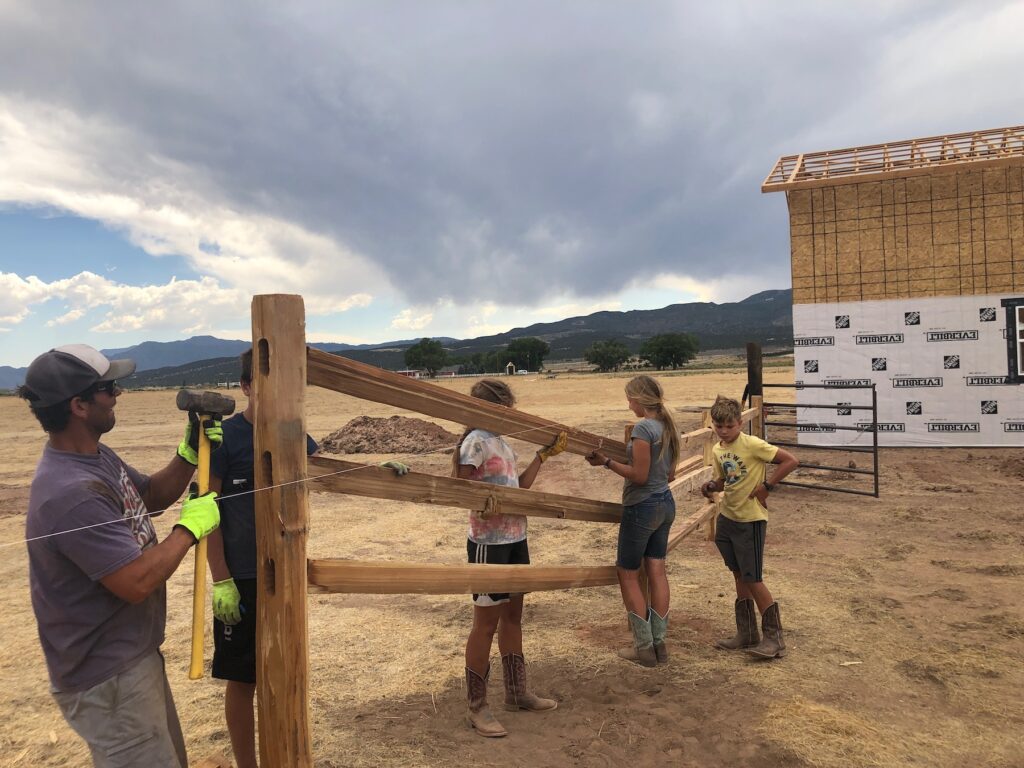 family building a fence at The Grand Ranch